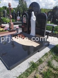 Памятник с Богородицей на кладбище.  Мраморный барельеф Богородицы на памятнике.
