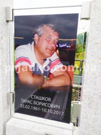 Памятник с портретом мужчины в стекле. Фото на кладбище.